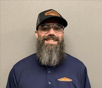 SERVPRO employee in front of beige wall. 